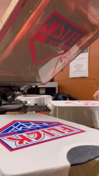 Pantalla aixecada al pulpo del taller amb samarretes de Flick acabades d'estampar